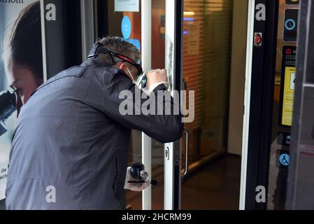 Vendrell, Spanien. 31st Dez 2021. Ein Agent der Diebstahluntersuchungsgruppe der katalanischen Polizei sucht an der Eingangstür des Bankbüros der CaixaBank nach den Fingerabdrücken des Räubers ein Mann mit einem Messer führt in einem Büro der Bank CaixaBank in El Vendrell (Tarragona, Spanien) einen Raub durch Flucht mit einer Sammlung, die noch von den Bankverantwortlichen bestimmt werden muss. Die katalanische Polizei untersucht den Ort des Diebstahls und sucht nach Fingerabdrücken des Räubers (Foto: Ramon Costa/SOPA Images/Sipa USA) Quelle: SIPA USA/Alamy Live News Stockfoto