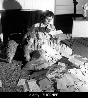 Um 1957, Hollywood, Kalifornien, USA: Die amerikanische Schauspielerin und Komikerin BETTY WHITE sitzt mit ihrem Hund auf dem Boden mit einem riesigen Haufen Fanpost. (Bild: © Globe Photos/ZUMA Press Wire) Stockfoto