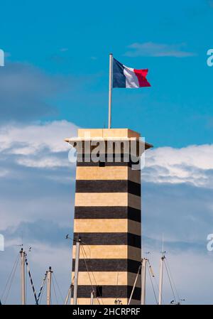 Deauville, Frankreich - 6. August 2021: Der Hafen von Marina und sein Turm mit französischer Flagge in Trouville, Normandie, Frankreich. Stockfoto