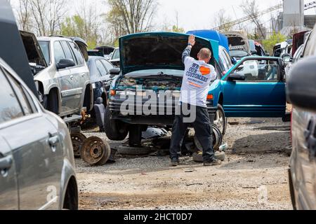 Ein Mann prüft diese blaue Oldsmobile Cutlass Supreme auf Teile auf der LKQ Wählen Sie Ihre Teil Auto Bergungswerft in Fort Wayne, Indiana, USA. Stockfoto