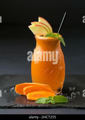 Glas mit Apfel - Karottensaft und Zutaten auf Holz Hintergrund Stockfoto