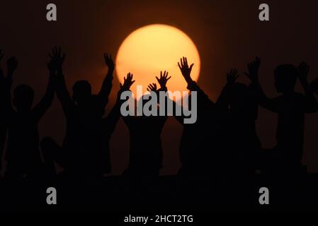 Lahore, Punjab, Pakistan. 31st Dez 2021. Pakistanische Kinderspiele als Routine bei einem attraktiven, atemberaubenden Blick auf den letzten Sonnenuntergang des Jahres 2021, aufgenommen über dem Horizont von Lahore. (Bild: © Rana Sajid Hussain/Pacific Press via ZUMA Press Wire) Stockfoto