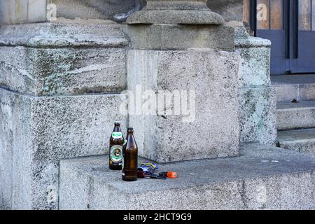 Zwei Bierflaschen, Tabak und eine Pfeife auf der Treppe eines Hauseingangs. Stockfoto