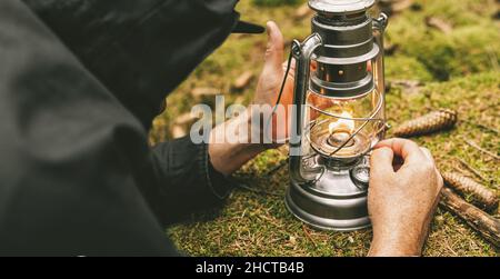 Wanderer zünden eine Gasoline Laterne im Wald. Authentische Nahaufnahme. Bild des Reisekonzepts Stockfoto