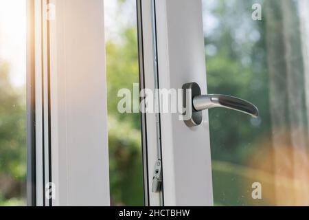 Geöffnetes weißes Plastikfenster mit Sonnenlicht Stockfoto