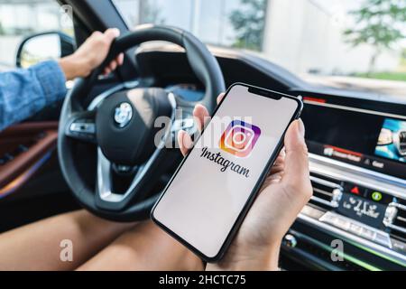 Frau Hand hält iphone XS mit Logo der instagram-Anwendung in einem Auto. Instagram ist das größte und beliebteste Foto-Social-Networking. Stockfoto