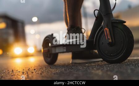 Junger Mann in der Nacht mit Elektroroller oder E-Scooter in der Stadt, Elektro Stadtverkehr Konzept Bild Stockfoto