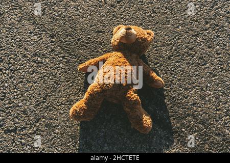 Verlorener Teddybär, der nach einem Unfall auf der Straße lag, mit Skidmarks Stockfoto