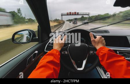 Auto an einem regnerischen Tag auf einer Autobahn fahren - POV, aus der Sicht der ersten Person Stockfoto