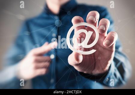 Junger Geschäftsmann mit E-Mail-Schild (AT-Schild) Stockfoto