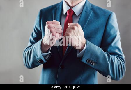 Geschäftsmann, der die Faust hebt und den Sieg mit den Händen feiert - Geschäftsgeste und Menschenbild Stockfoto