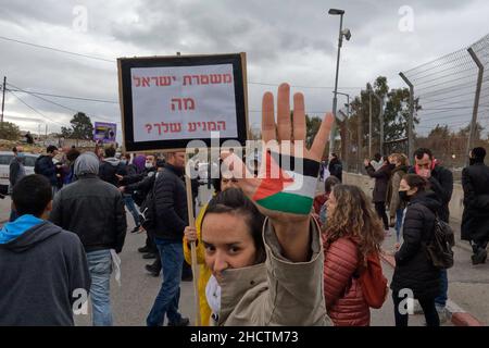 Eine israelische linke Aktivistin hebt ihre Hand, gemalt mit den Farben der palästinensischen Flagge, während einer Demonstration gegen die Vertreibung palästinensischer Familien aus ihren Häusern und Siedlungsaktivitäten im Stadtteil Sheikh Jarrah am 31. Dezember 2021 in Jerusalem, Israel. Das palästinensische Viertel Sheikh Jarrah ist derzeit das Zentrum einer Reihe von Eigentumsstreitigkeiten zwischen Palästinensern und rechtsgerichteten jüdischen Israelis. Einige Häuser wurden nach einem Gerichtsurteil von israelischen Siedlern besetzt. Stockfoto