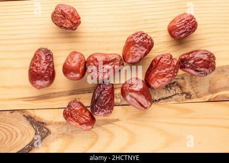 Mehrere süße getrocknete ziziphus-Beeren auf einem Holztisch, Nahaufnahme, Draufsicht. Stockfoto