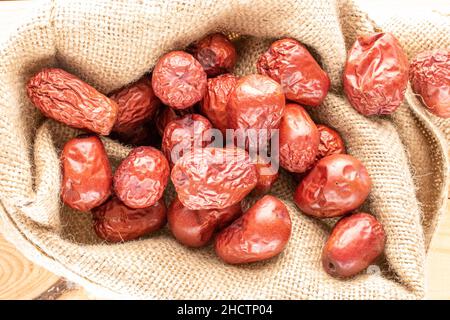 Mehrere süße getrocknete ziziphus-Beeren in einer Jute-Tüte, Nahaufnahme, Draufsicht. Stockfoto