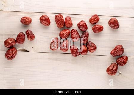 Mehrere süße getrocknete ziziphus-Beeren auf einem Holztisch, Nahaufnahme, Draufsicht. Stockfoto