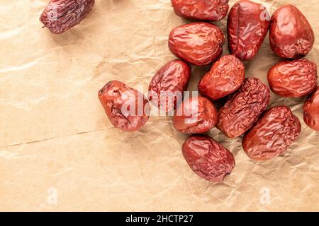 Mehrere süße getrocknete ziziphus-Beeren auf Bastelpapier, Nahaufnahme, Draufsicht. Stockfoto