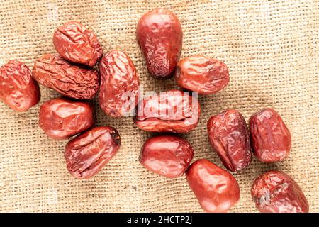 Mehrere süße getrocknete ziziphus-Beeren auf Sackleinen, Nahaufnahme, Draufsicht. Stockfoto