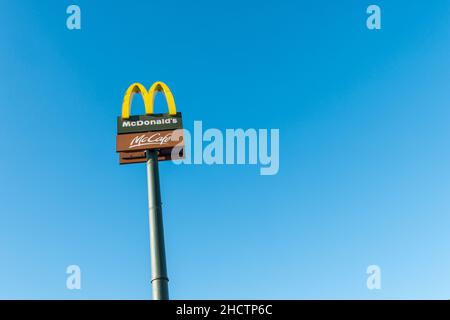 McDonald's Restaurant Schild gegen blauen Himmel. Die McDonald's Corporation ist die weltweit größte Kette von Hamburger Fast-Food-Restaurants. Stockfoto