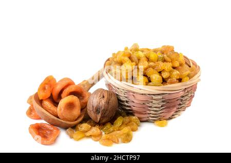 Rosinen in einem Korb und andere Früchte auf weißem Hintergrund mit weichem Schatten Stockfoto