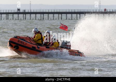 Jubilee Beach, Southend on Sea, Essex, Großbritannien. 1st Januar 2022. Die Menschen haben sich für wohltätige Zwecke in die kalten Gewässer der Themsemündung gebracht, um Gelder für die lokale Niederlassung der Royal National Lifeboat Institution zu sammeln. Mitglieder der RNLI waren aus Sicherheitsgründen zur Verfügung, viele der Schwimmer trugen Kostüme in schicken Kleidern. Rund 300 Personen nahmen daran Teil. RNLI Rettungsboot mit Schutzabdeckung Stockfoto