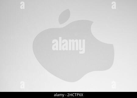 Weißes Apple-Logo auf gebürstetem Aluminium-Hintergrund. Apple ist das weltweit größte börsennotierte Unternehmen, das Unterhaltungselektronik und andere Produkte entwickelt und vertreibt Stockfoto