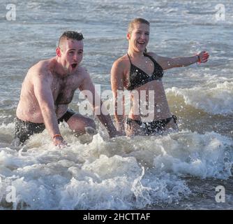 Irvine, Großbritannien. 1st Januar 2022. Mehr als 150 Schwimmer nahmen am Annual Loony Dook Swim vor dem Strand von Irvine bei Meerestemperaturen von weniger als 9C Teil. Viele der Schwimmer, die daran teilnahmen, sammeln Gelder für lokale und nationale Wohltätigkeitsorganisationen Kredit: Findlay/Alamy Live News Stockfoto