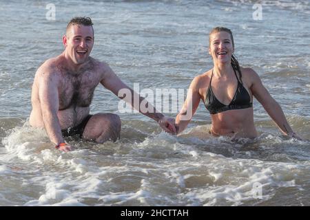 Irvine, Großbritannien. 1st Januar 2022. Mehr als 150 Schwimmer nahmen am Annual Loony Dook Swim vor dem Strand von Irvine bei Meerestemperaturen von weniger als 9C Teil. Viele der Schwimmer, die daran teilnahmen, sammeln Gelder für lokale und nationale Wohltätigkeitsorganisationen Kredit: Findlay/Alamy Live News Stockfoto