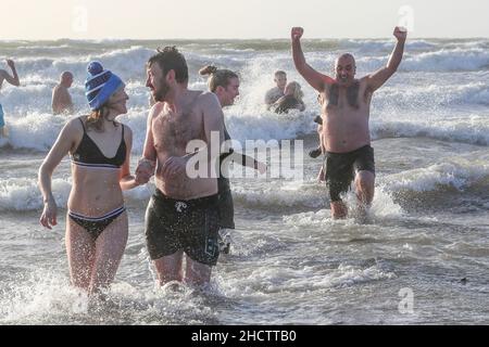 Irvine, Großbritannien. 1st Januar 2022. Mehr als 150 Schwimmer nahmen am Annual Loony Dook Swim vor dem Strand von Irvine bei Meerestemperaturen von weniger als 9C Teil. Viele der Schwimmer, die daran teilnahmen, sammeln Gelder für lokale und nationale Wohltätigkeitsorganisationen Kredit: Findlay/Alamy Live News Stockfoto