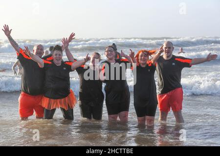 Irvine, Großbritannien. 1st Januar 2022. Mehr als 150 Schwimmer nahmen am Annual Loony Dook Swim vor dem Strand von Irvine bei Meerestemperaturen von weniger als 9C Teil. Viele der Schwimmer, die daran teilnahmen, sammeln Gelder für lokale und nationale Wohltätigkeitsorganisationen Kredit: Findlay/Alamy Live News Stockfoto