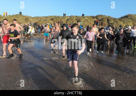 Irvine, Großbritannien. 1st Januar 2022. Mehr als 150 Schwimmer nahmen am Annual Loony Dook Swim vor dem Strand von Irvine bei Meerestemperaturen von weniger als 9C Teil. Viele der Schwimmer, die daran teilnahmen, sammeln Gelder für lokale und nationale Wohltätigkeitsorganisationen Kredit: Findlay/Alamy Live News Stockfoto