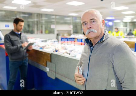 Männer halten Technologie in Recycling-Zentrum Stockfoto