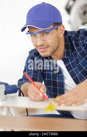 Mann mit Maßband und Bleistift in der Werkstatt Stockfoto