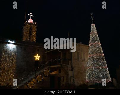 Mi'ilia, Israel - 25th. Dezember 2021: Die Kirche und ein weihnachtsbaum, geschmückt zu weihnachten in dem arabisch-christlichen Dorf Mi'ilia, Israel, in der Nähe Stockfoto