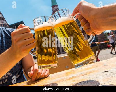 Zwei männer halten Bierkrug in einem Biergarten in deutschland Stockfoto