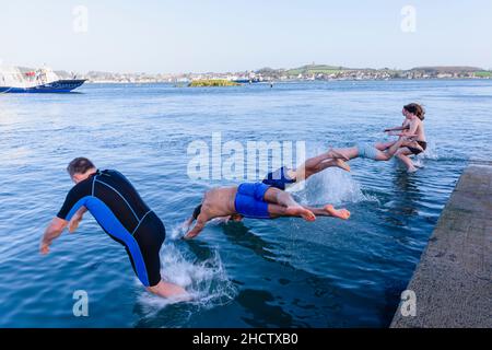 01/01/2022-Schwimmer tauchen und springen ins Meer zu Beginn des jährlichen Schwimmens im kalten Wasser am Neujahrstag in Strangford, Nordirland Stockfoto