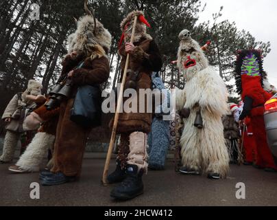 Mummers in traditionellen Kostümen tourten am ersten Tag des Jahres 2022 durch die Straßen von Godech. Menschen mit einer Maske namens Kukeri tanzen Stockfoto