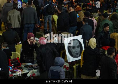 Mosul, Irak. 31st Dez 2021. Während der Neujahrsfeiern versammeln sich die Menschen, um ein Gemälde mit Faden und Nägeln zu sehen, das Angelina Jolie im archäologischen Khan Al-Gumruk in der Altstadt von Mosul darstellt. Kredit: SOPA Images Limited/Alamy Live Nachrichten Stockfoto