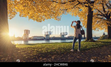 Frau macht im Herbst ein Bild von der Skyline von Köln Stockfoto