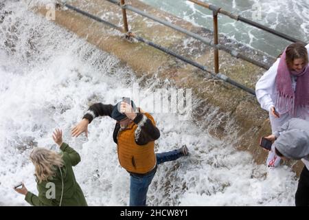 Portreath,Cornwall,1st. Januar 2022,große Wellen und stürmische Meere in Portreath,Cornwall, verursacht durch starke Südwestwinde heute Morgen. Zwei Menschen wurden von den Wellen gefangen, als sie über die Hafenmauer kamen, sodass sie wegliefen und dabei durchnässt wurden.die Temperatur lag bei 13C, was für die Jahreszeit mild ist. Die Prognose ist, dass es sich um stürmische Winde für heute handelt, die sich heute Abend beruhigen werden.Quelle: Keith Larby/Alamy Live News Stockfoto