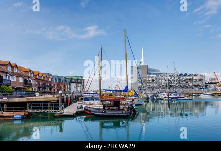 Segelboote, die an Apartments am Wasser in Camber Quay in Portsmouth Harbour, Hampshire, Südküste Englands, festgemacht sind Stockfoto