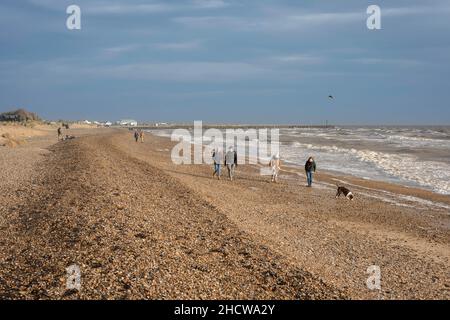 Walberswick Beach, außerhalb der Saison Ansicht von Menschen, die auf dem Kiesstrand in Walberswick, Suffolk, England, Großbritannien, spazieren gehen Stockfoto