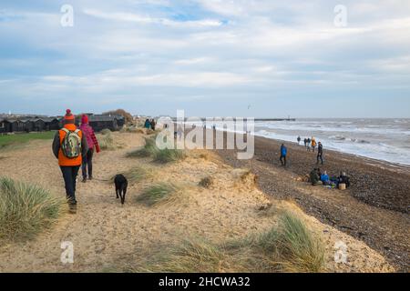 Suffolk Coast Path, außerhalb der Saison Ansicht von Menschen, die durch Sanddünen auf dem Suffolk Coast Path am Walberswick Beach, Suffolk, England, wandern Stockfoto