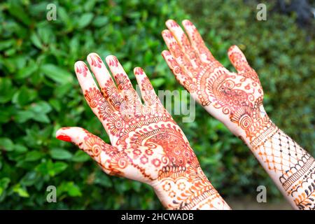 Die Hände der Frau oder Braut sind in Mehndi dekoriert, einer Form von Körperkunst und vorübergehender Hautdekoration, die in der Regel auf Händen oder Beinen gezeichnet wird. Stockfoto