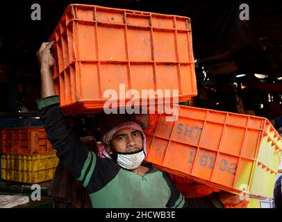 Der junge Mann, der mit der Fischerei arbeitet, ist während der Pandemie auf dem Fischgroßmarkt in Kalkutta, Westbengalen in Indien, beschäftigt. Stockfoto