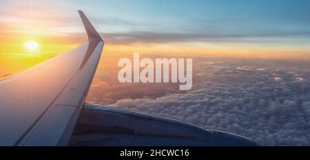 Blick auf den Sonnenuntergang und flugzeugflügel von Innen Stockfoto