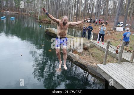 Wendell, North Carolina, USA. 1st Januar 2022. DALE MORRILL springt 50 Grad Mystery Lake, während Dutzende am fünften jährlichen Neujahrstag Polar Plunge im Mystery Lake Scuba Park in Wendell, North Carolina, teilnahmen. Alle Erlöse gehen an Mütter gegen betrunkenes Fahren (MADD). Der See ist ein 105 Meter tiefer Steinbruch, in dem einst in den 1920er Jahren Granit abgebaut wurde, um lokale Autobahnen zu bauen. (Bild: © Bob Karp/ZUMA Press Wire) Stockfoto