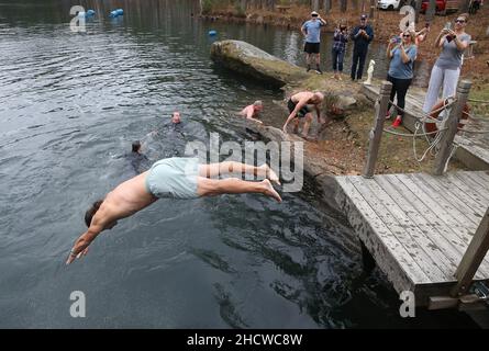 Wendell, North Carolina, USA. 1st Januar 2022. Dutzende nahmen an dem fünften jährlichen Polar-Tauchgang am Neujahrstag im Mystery Lake Scuba Park in Wendell, North Carolina, Teil. Der gesamte Erlös ging an Mütter gegen betrunkenes Fahren (MADD). Der 50-Grad-Mystery Lake ist ein 105 Meter tiefer Steinbruch, in dem einst in den 1920er Jahren Granit abgebaut wurde, um lokale Autobahnen zu bauen. (Bild: © Bob Karp/ZUMA Press Wire) Stockfoto