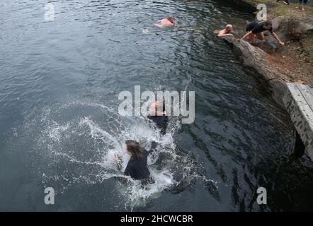 Wendell, North Carolina, USA. 1st Januar 2022. Dutzende nahmen an dem fünften jährlichen Polar-Tauchgang am Neujahrstag im Mystery Lake Scuba Park in Wendell, North Carolina, Teil. Der gesamte Erlös ging an Mütter gegen betrunkenes Fahren (MADD). Der 50-Grad-Mystery Lake ist ein 105 Meter tiefer Steinbruch, in dem einst in den 1920er Jahren Granit abgebaut wurde, um lokale Autobahnen zu bauen. (Bild: © Bob Karp/ZUMA Press Wire) Stockfoto