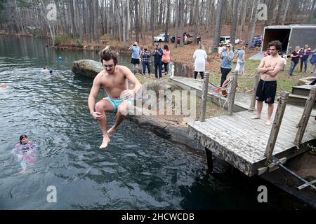 Wendell, North Carolina, USA. 1st Januar 2022. BRIGSTON VARDY von Wendell, NC springt 50 Grad Mystery Lake, als Dutzende am fünften jährlichen Neujahrstag Polar Plunge im Mystery Lake Scuba Park in Wendell, North Carolina, teilnahmen. Alle Erlöse gehen an Mütter gegen betrunkenes Fahren (MADD). Der See ist ein 105 Meter tiefer Steinbruch, in dem einst in den 1920er Jahren Granit abgebaut wurde, um lokale Autobahnen zu bauen. (Bild: © Bob Karp/ZUMA Press Wire) Stockfoto