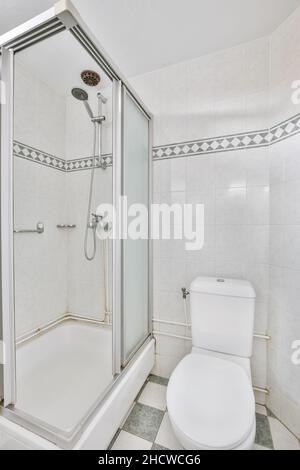 Kleines Badezimmer mit weißen Schränken, Granitablagen und Toilette. Stockfoto